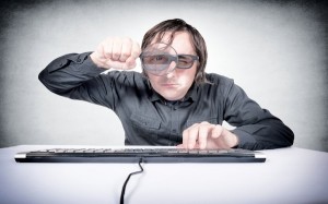 Guy with magnifying glass peeping at passwords
