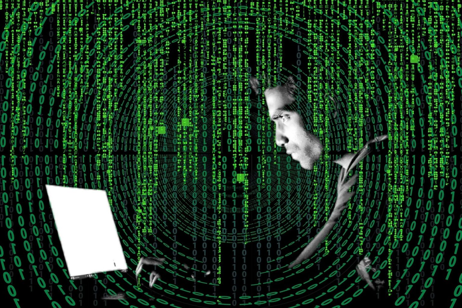 side view of mysterious half-lit man looking at a computer screen, surrounded by concentric circles of ones and zeroes and Matrix-like vertical computer code all in glowing green on a black background